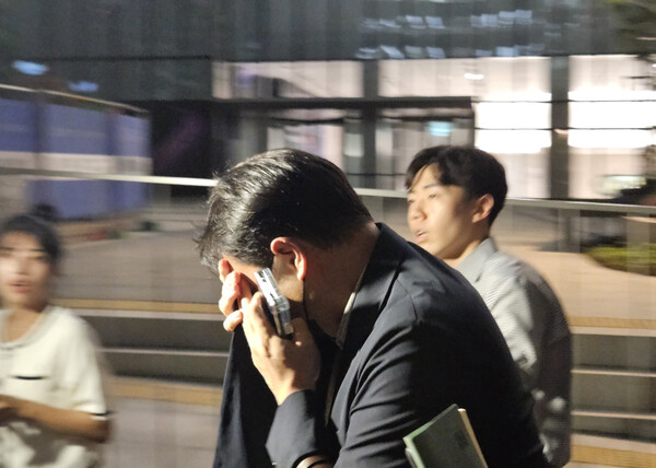 김건희 씨 오빠 김진우 씨가 28일 민중기 특별검사팀 사무실이 위치한 서울 종로구 KT광화문빌딩에서 조사를 마친 뒤 얼굴을 가린 채 특검 사무실을 나서고 있다. 2025.7.28. 연합뉴스