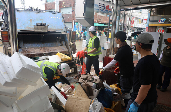 18일 오전 집중호우로 침수된 충남 당진시 읍내동 당진전통시장에서 못 쓰게 된 집기류 등 쓰레기가 가득한 가운데, 복구작업이 한창이다. 2025.7.18. 연합뉴스