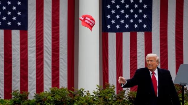 사진 1. 4월 2일, 백악관에서 관세부과 조치를 발표하며 마가 모자를 날리는 트럼프. 사진 블룸버그.