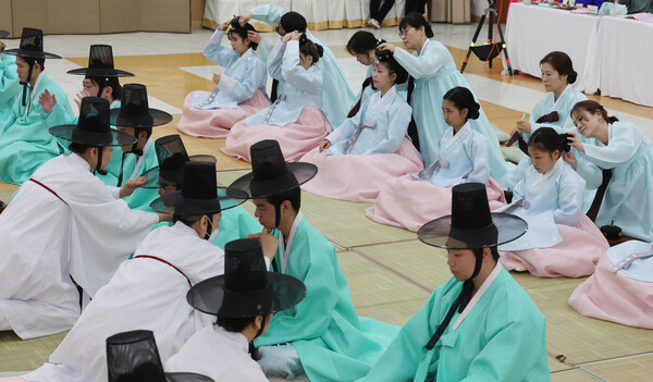 제53회 성년의 날인 19일 부산 사상구 부산여성문화회관에서 열린 기념식에서 올해 성년이 된 2006년생 청소년들에게 족두리와 갓을 씌워주고 있다. 성년의 날은 매년 5월 셋째 주 월요일로 법정기념일이다. 2025.5.19 연합뉴스