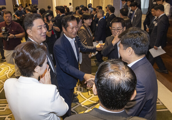 더불어민주당 정청래 대표와 김병기 원내대표가 29일 인천시 중구 파라다이스시티 컨벤션에서 열린 2025 정기국회 더불어민주당 의원단 워크숍에서 결의문을 채택한 뒤 동료 의원들과 악수하고 있다. 2025.8.29. 연합뉴스