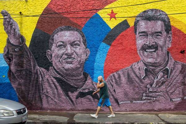 베네수엘라 카라카스에서 반미 집회가 벌어지는 가운데 29일 한 시민이 니콜라스 마두로 대통령(사진을 바라보며 왼쪽)과 고 우고 차베스 전 대통령의 뮤럴 옆을 지나고 있다. 2025. 08. 29 [EPA=연합뉴스]