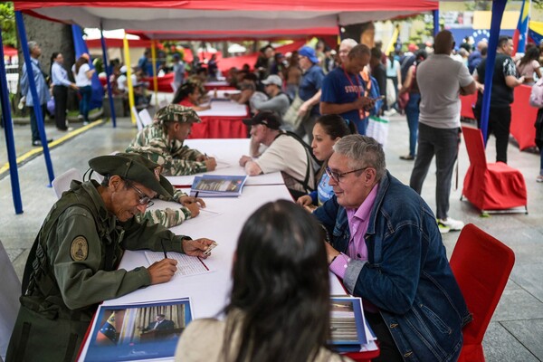 베네수엘라 카라카스의 볼리바르 광장에서 29일 시민들이 미 제국주의에 맞서자는 니콜라스 마두로 대통령의 호소에 따라 민병대 입대에 나서고 있다.  2025. 08. 29 [AFP=연합뉴스]
