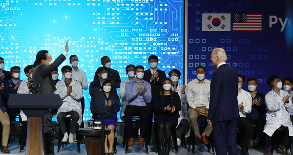 윤석열 대통령이 20일 오후 경기도 평택시 삼성전자 반도체 공장을 방문한 조 바이든 미 대통령 연설이 끝난 뒤 화면에 등장한 삼성전자 미국 공장 직원들과 인사하고 있다. 2022.5.20 연합뉴스