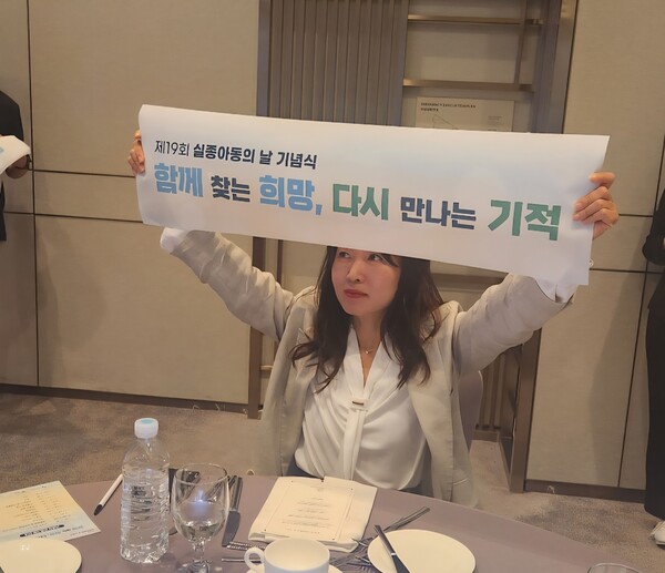 제 19회 세계 실종아동의날 기념식장 앞에서 손 현수막을 들고 있는 배진시 몽테뉴해외입양연대 대표.