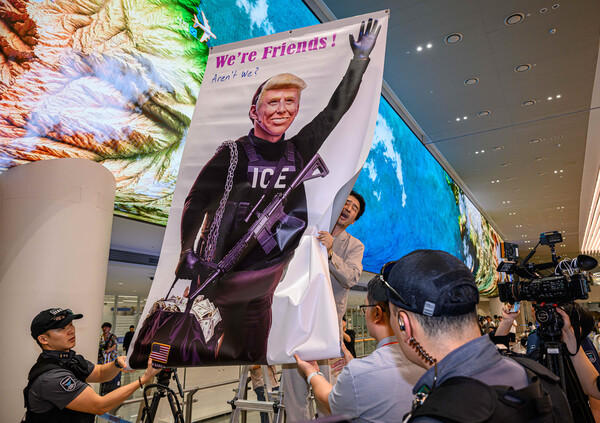 미국 이민당국에 의해 조지아주에 구금됐던 한국인 근로자들이 귀국한 12일 인천국제공항 제2여객터미널 입국장에서 이제석 이제석광고연구소 대표가 트럼프 미국 대통령의 모습이 담긴 플래카드 퍼포먼스를 벌이고 있다. 2025.9.12 [공동취재]