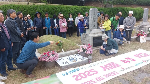‘2025 서울4.3학교’ 참여자들이 김학규 동작역사문화연구소장 안내로 서울현충원 4.3길을 순례하던 중 김익렬묘 앞에서 헌화하고 있다. © 이봉수
