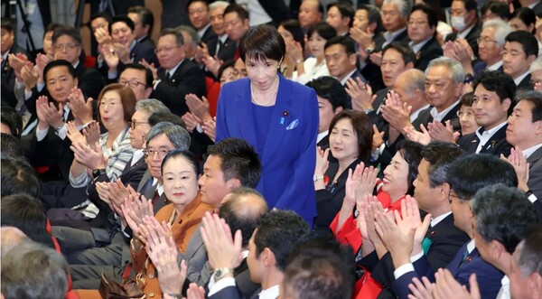 4일 자민당 총재선거에서 당선된 뒤 박수로 축하하는 동료 의원들에게 일어나서 화답하는 다카이치 사나에.    이코노미스트 10월 4일