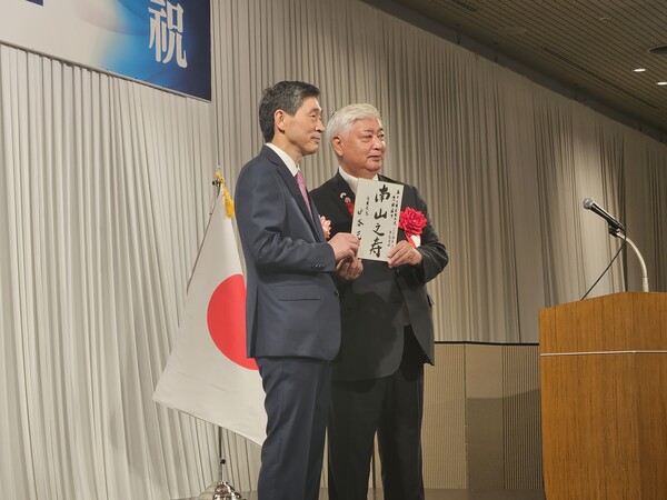 이혁 주일 한국대사(왼쪽)와 나카타니 겐 일본 방위상이 2일 일본 도쿄 뉴오타니호텔에서 주일본 한국대사관 주최로 열린 국경일(개천절) 및 국군의 날 기념 리셉션에서 함께 사진 촬영에 임하고 있다. 나카타니 방위상은 굳건한 한일관계를 바란다는 의미에서 장수를 기원하는 한자성어 '남산지수'(南山之壽)를 쓴 패널을 준비해왔다. 2025.10.2. 연합뉴스