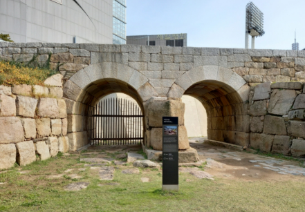 DDP 건설 공사를 앞두고 실시한 발굴 조사에서 모습을 드러낸 이간수문. 문화재위원회 결정에 따라 옛 모습 그대로 보존되고 있다. 뒤쪽으로 흔적만 남겨둔 동대문운동장 축구장 조명탑이 보인다. (서울시)