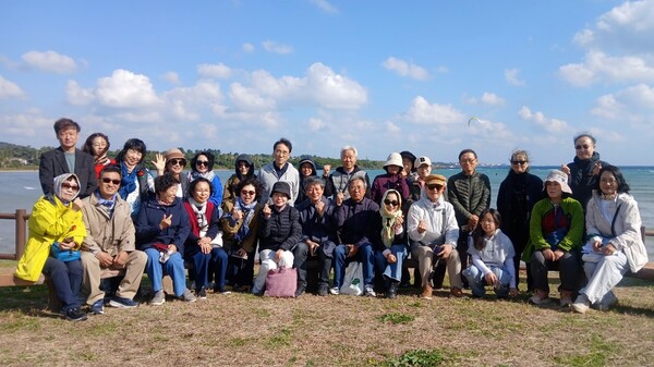 표선해수욕장 한모살에서 제주4.3범국민위원회 주최 ‘제주4.3문학기행’ 참가자들이 단체사진을 찍었다. © 하성태