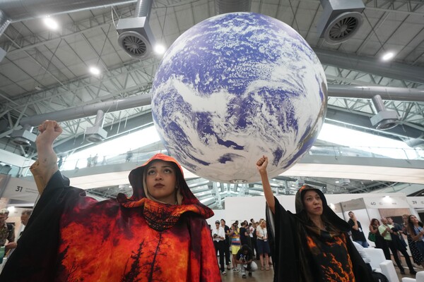 2025년 11월 21일, 브라질 벨렘에서 열린 제30차 유엔 기후변화총회(COP30)에서 활동가들이 지구본 아래 시위에 참여하고 있다.2025.11.21. AP 연합뉴스